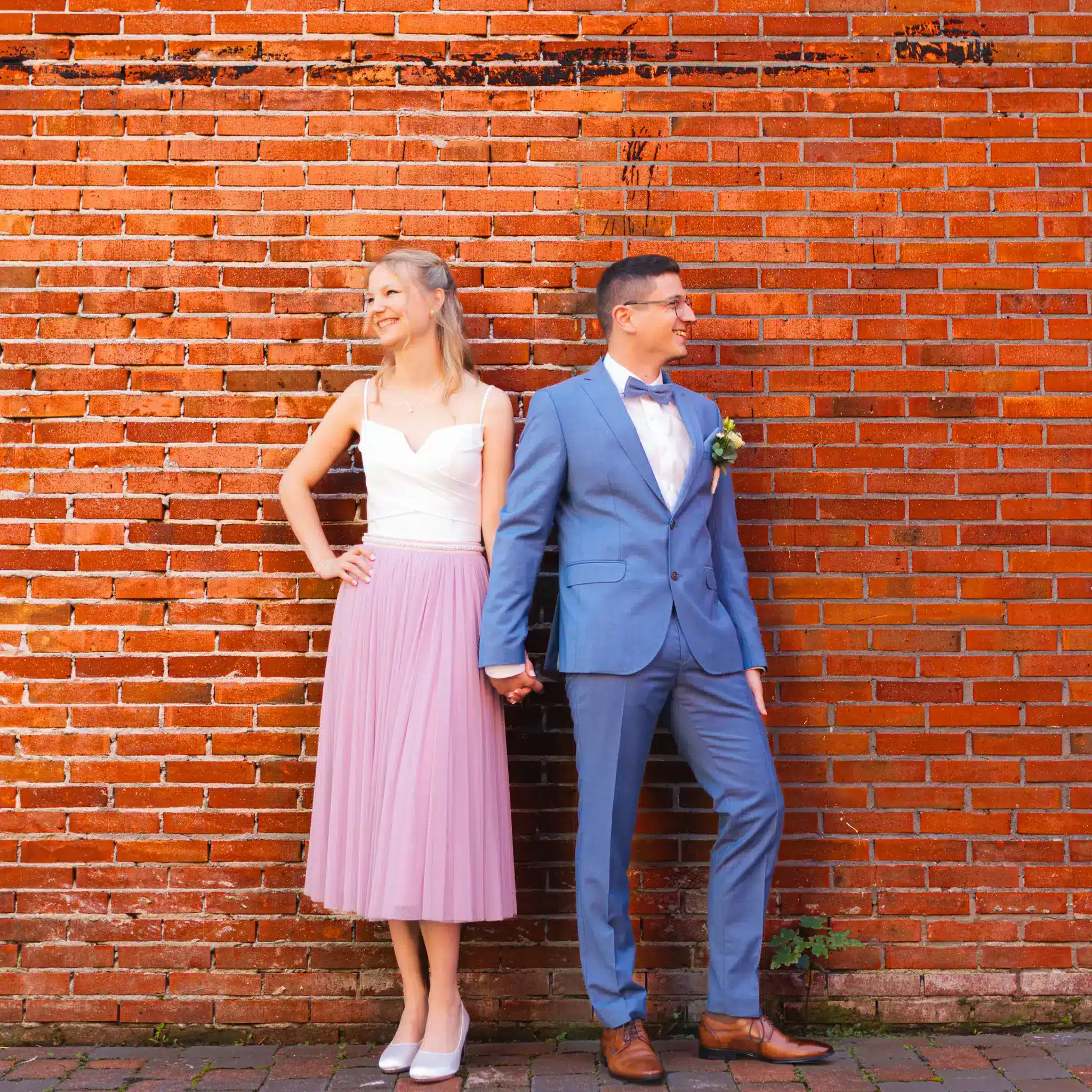 Laura und Michael stehen vor einer alten Steinmauer in der Innenstadt Leer.