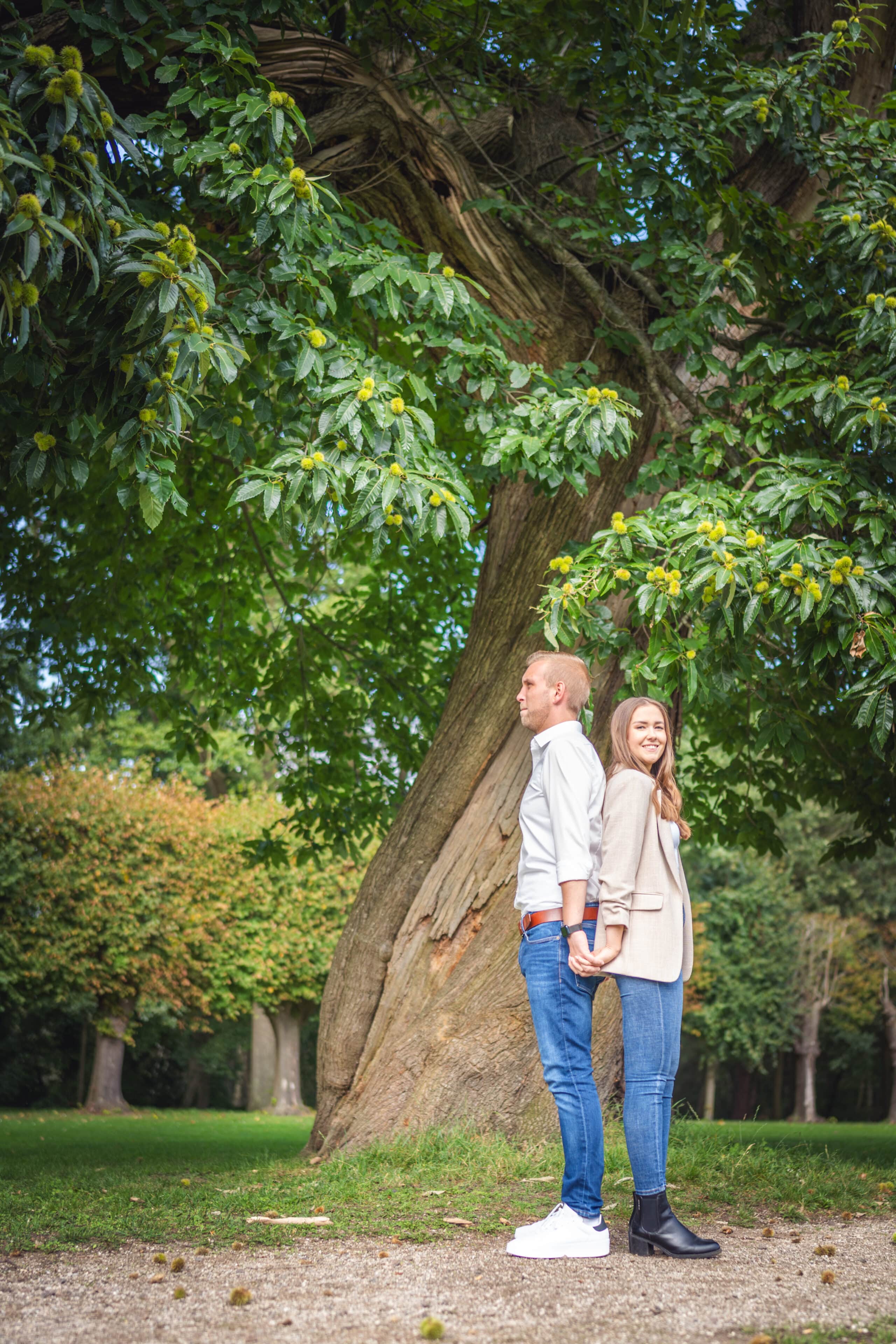 Jan und Lena stehen Rücken an Rücken und halten sich an den Händen, im Garten vom Gut Altenkamp in Aschendorf.